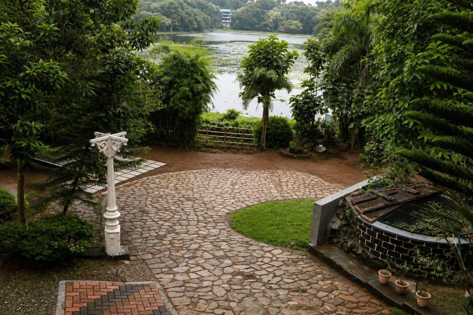 Stone courtyard path leading to Poomala Dam