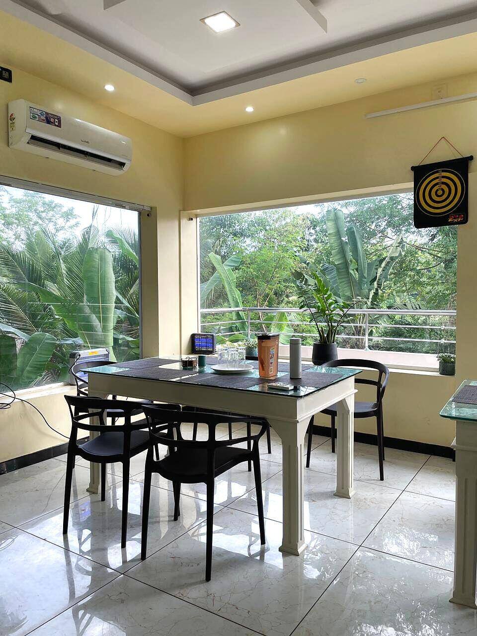 Glass-walled dining room overlooking greenery